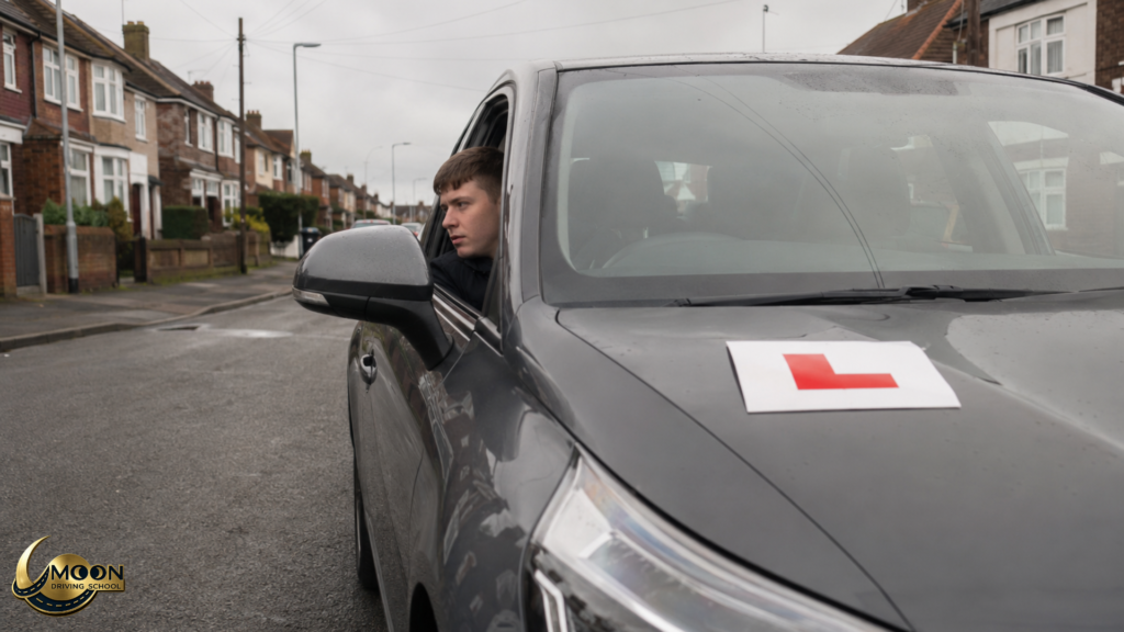 Learner driver checking surroundings from a car with L plates during a UK driving lesson